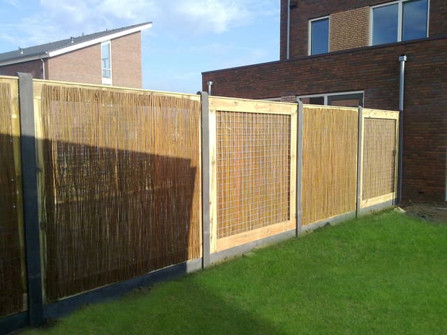 Houten schutting met rietmatten